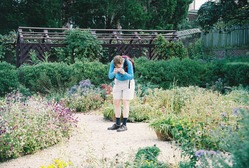 Scott bends over with his camera to photograph a butterfly.